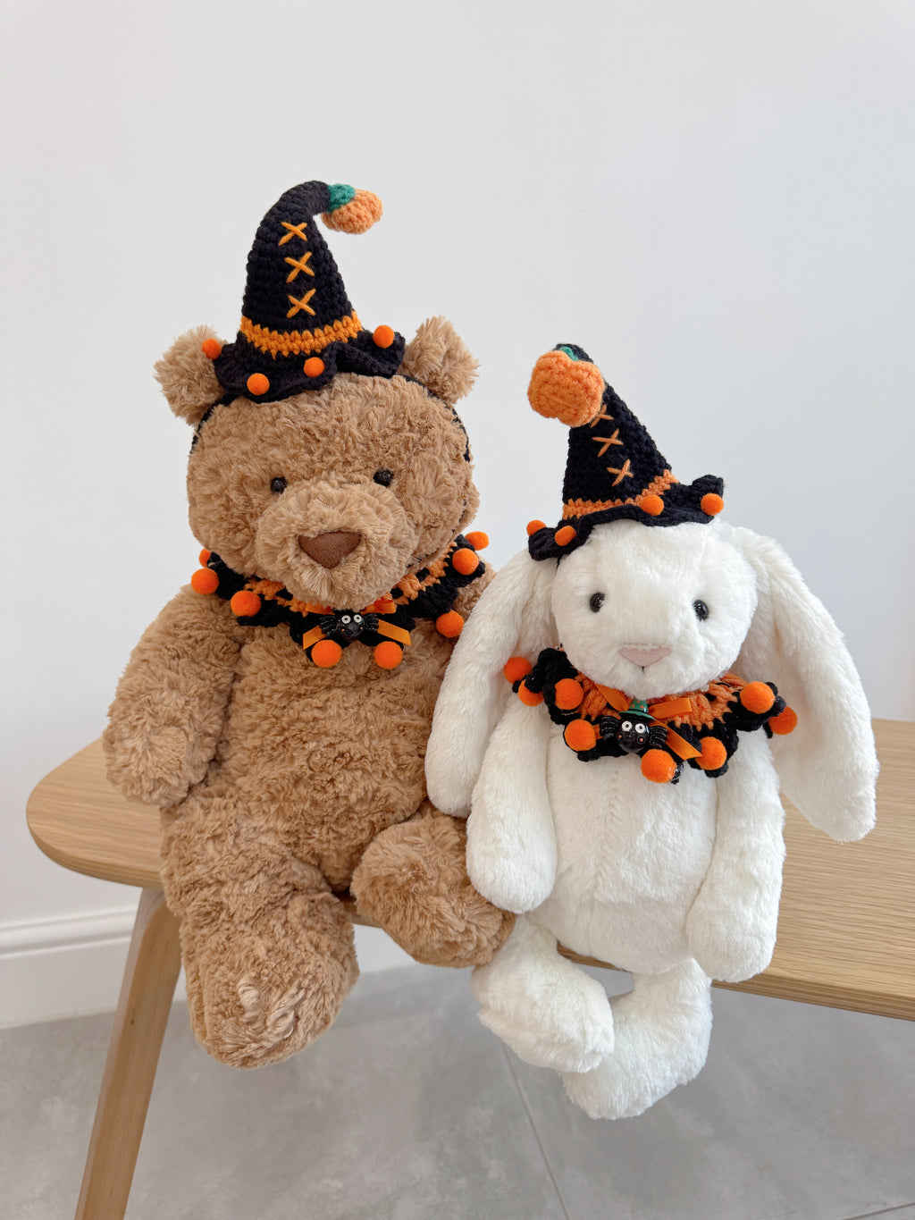 Plush bunny and bear wearing the same Halloween witch hat and collar accessory set