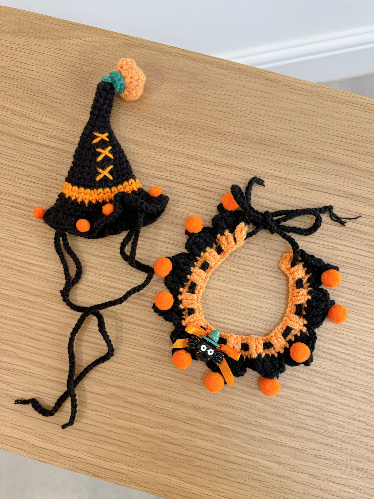 Black and orange crochet witch hat and ruffled collar set for plush toys with pumpkin and spider details