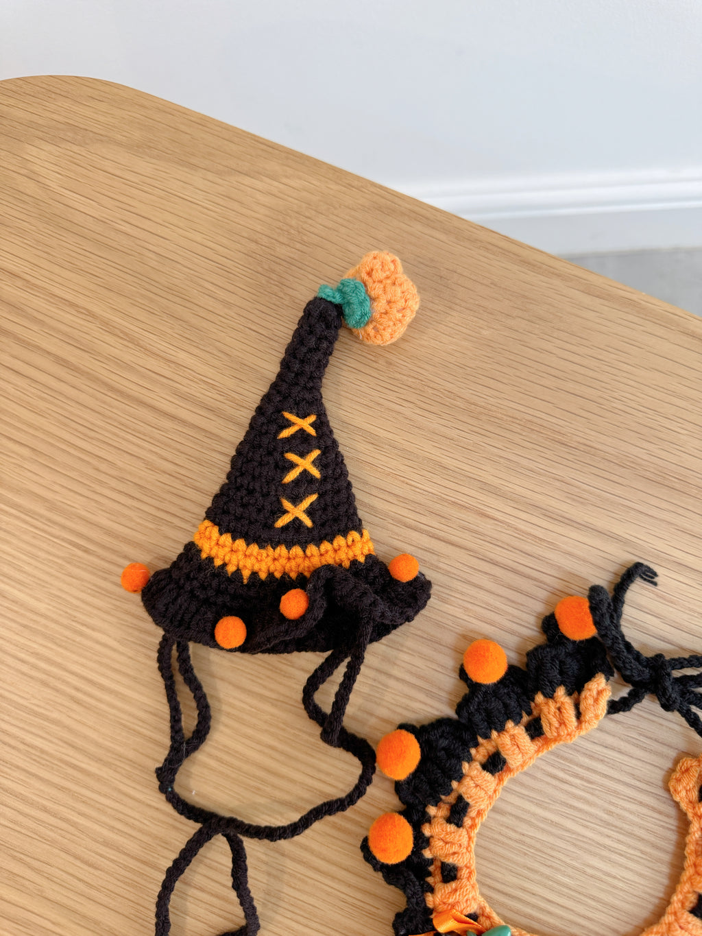 Black and orange crochet witch hat and ruffled collar set for plush toys with pumpkin and spider details