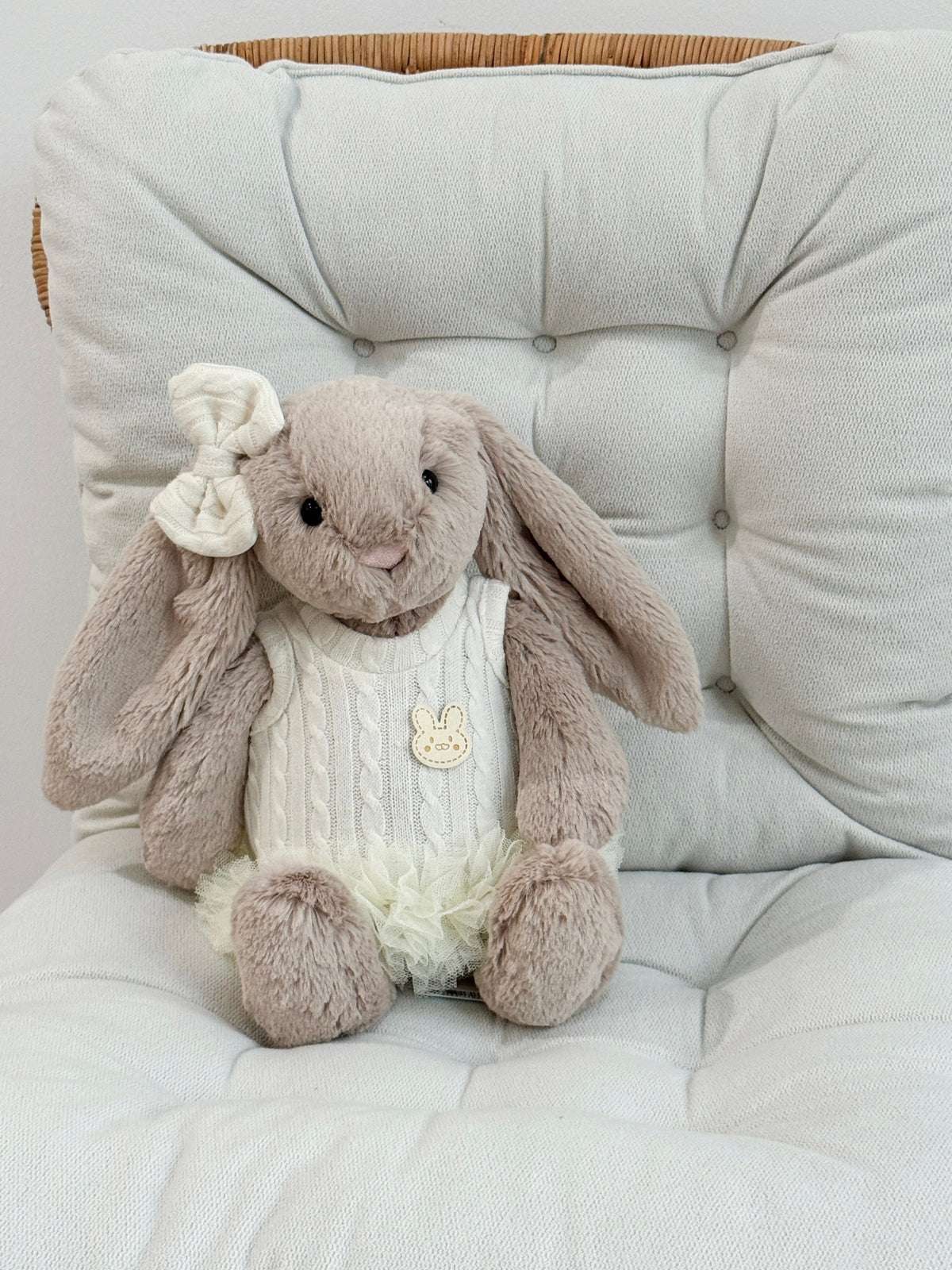 Beige plush bunny wearing an ivory cable knit tutu dress with layered tulle skirt and matching bow hair clip