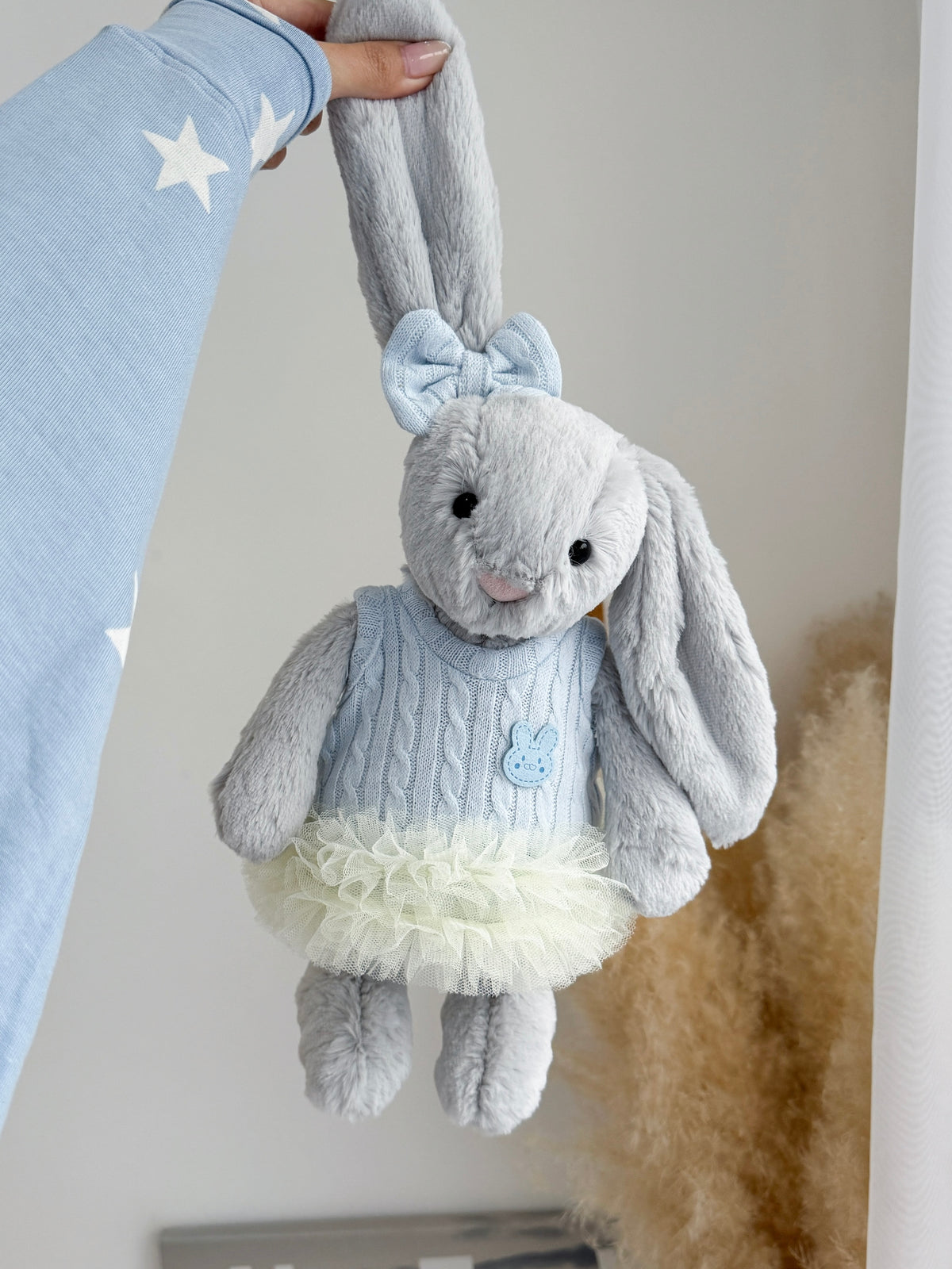 Silver plush bunny wearing a baby blue knitted dress with layered ivory tulle and matching bow