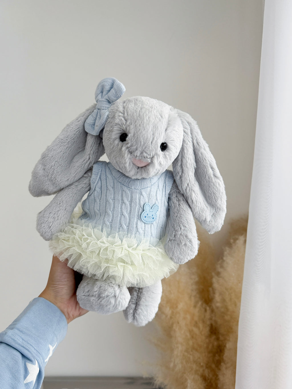 Silver plush bunny wearing a baby blue cable knit tutu dress with matching bow