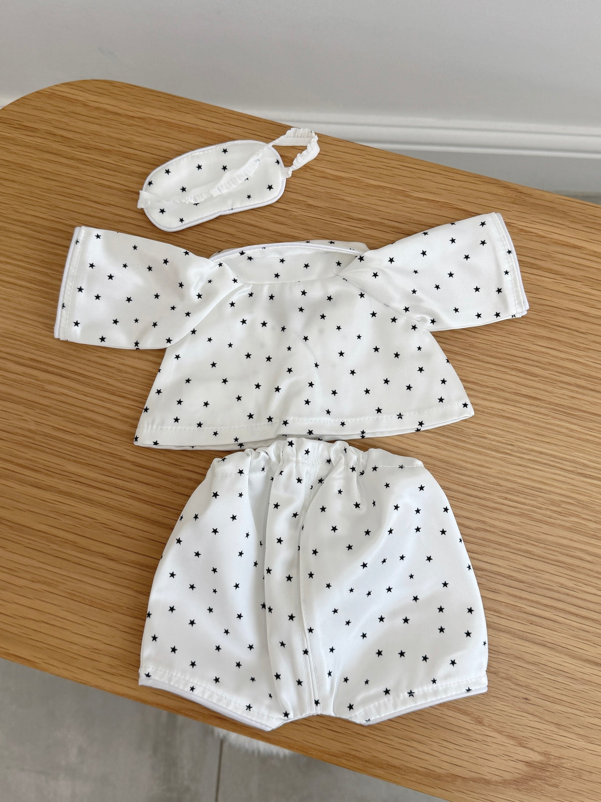 Back view of white star print pyjama top, shorts and sleep mask for a plush bunny