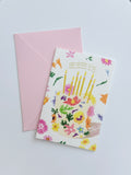 Colourful floral birthday greeting card with illustrated candles and coordinating pink envelop