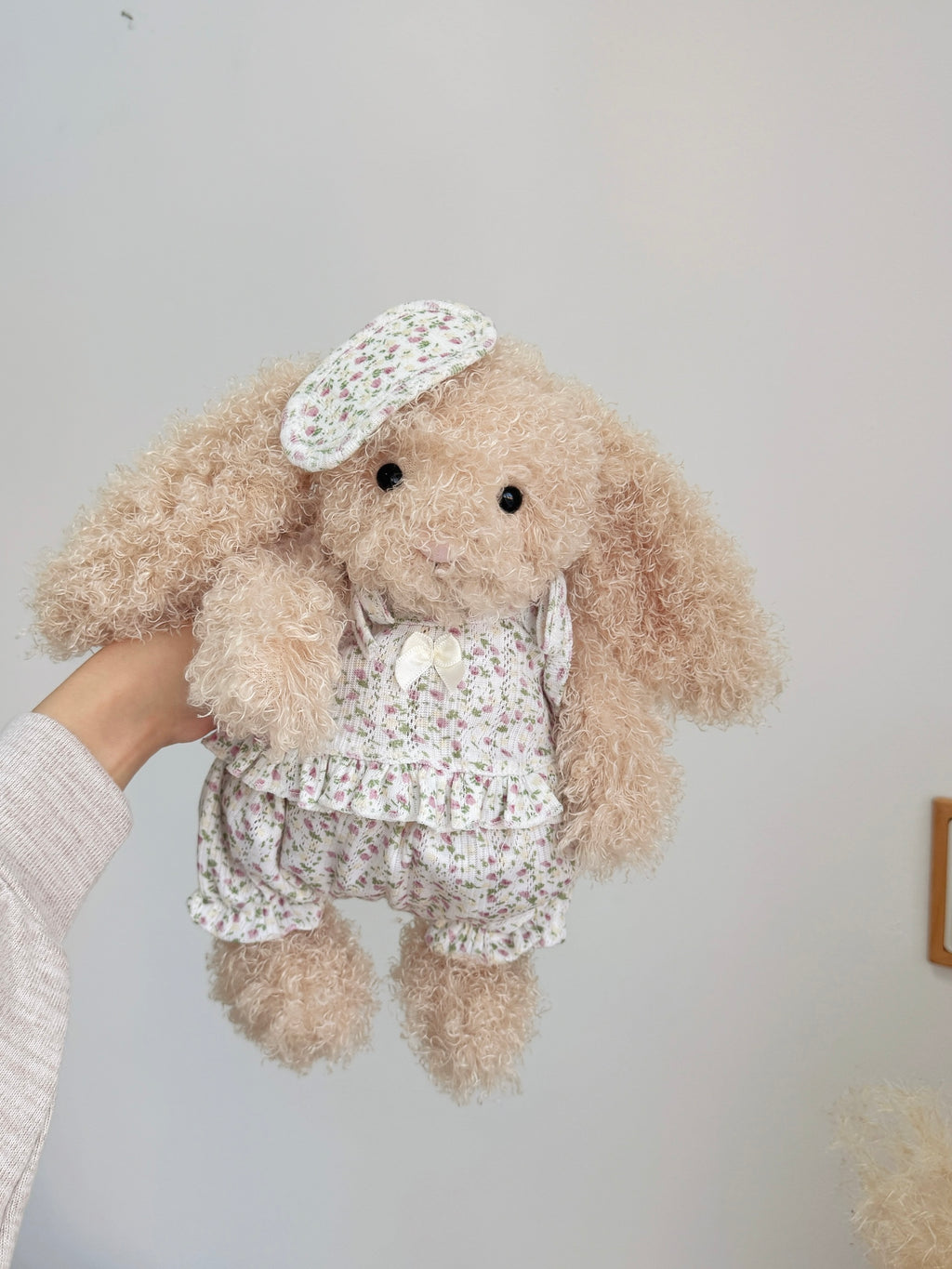 Beige curly-fur plush bunny wearing a pink floral cami top and bloomer shorts with matching sleep mask
