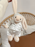 Cream plush bunny wearing a white star print pyjama set with matching sleep mask